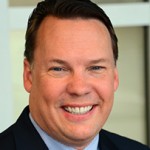 Man with dark hair smiling.