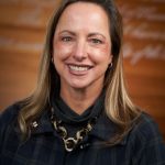 Beth Kubala in front of a brown background.