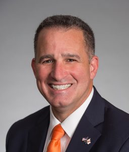 A man smiles while posing for a headshot.