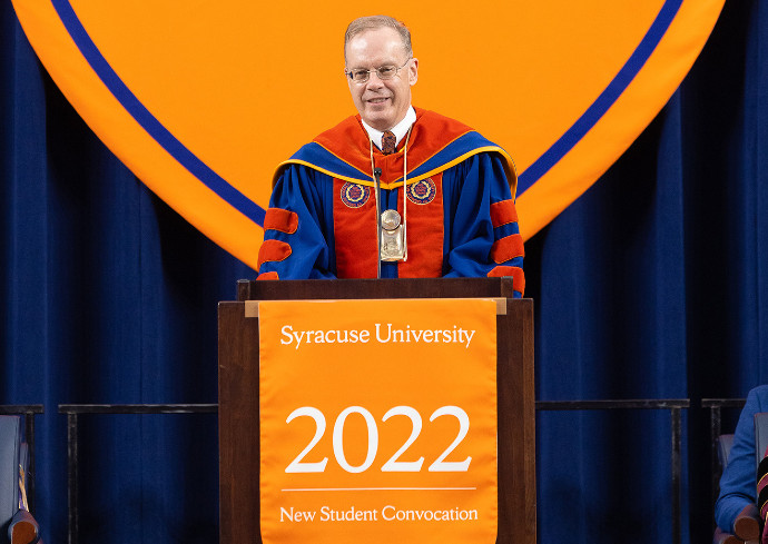 person in academic regalia standing at podium