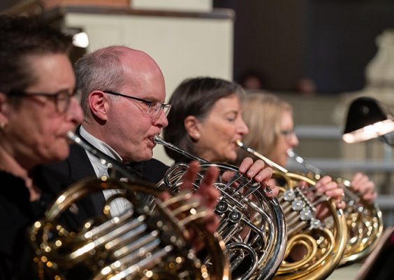 Four people playing horns.