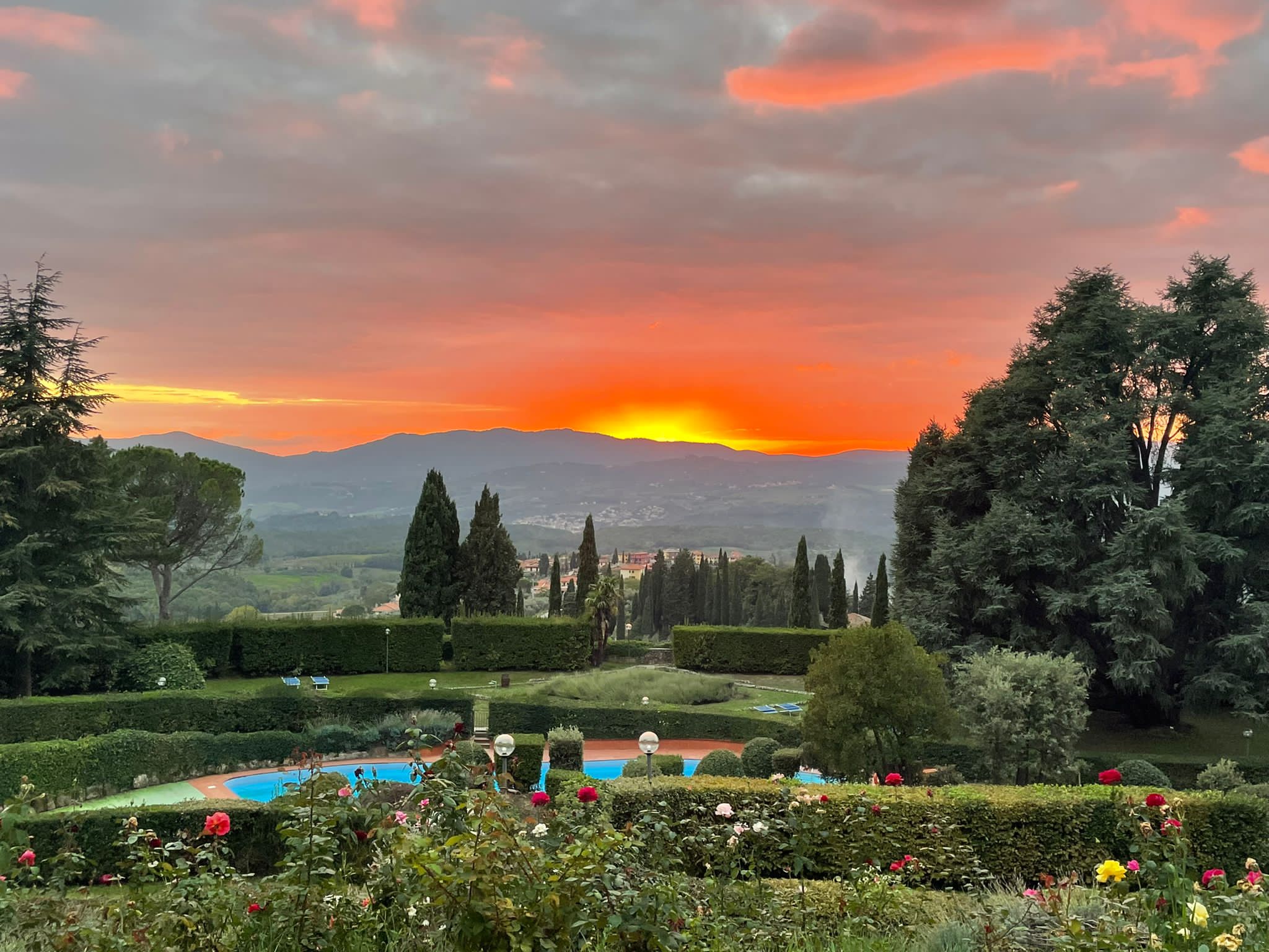 Orange sunset over rolling hills.