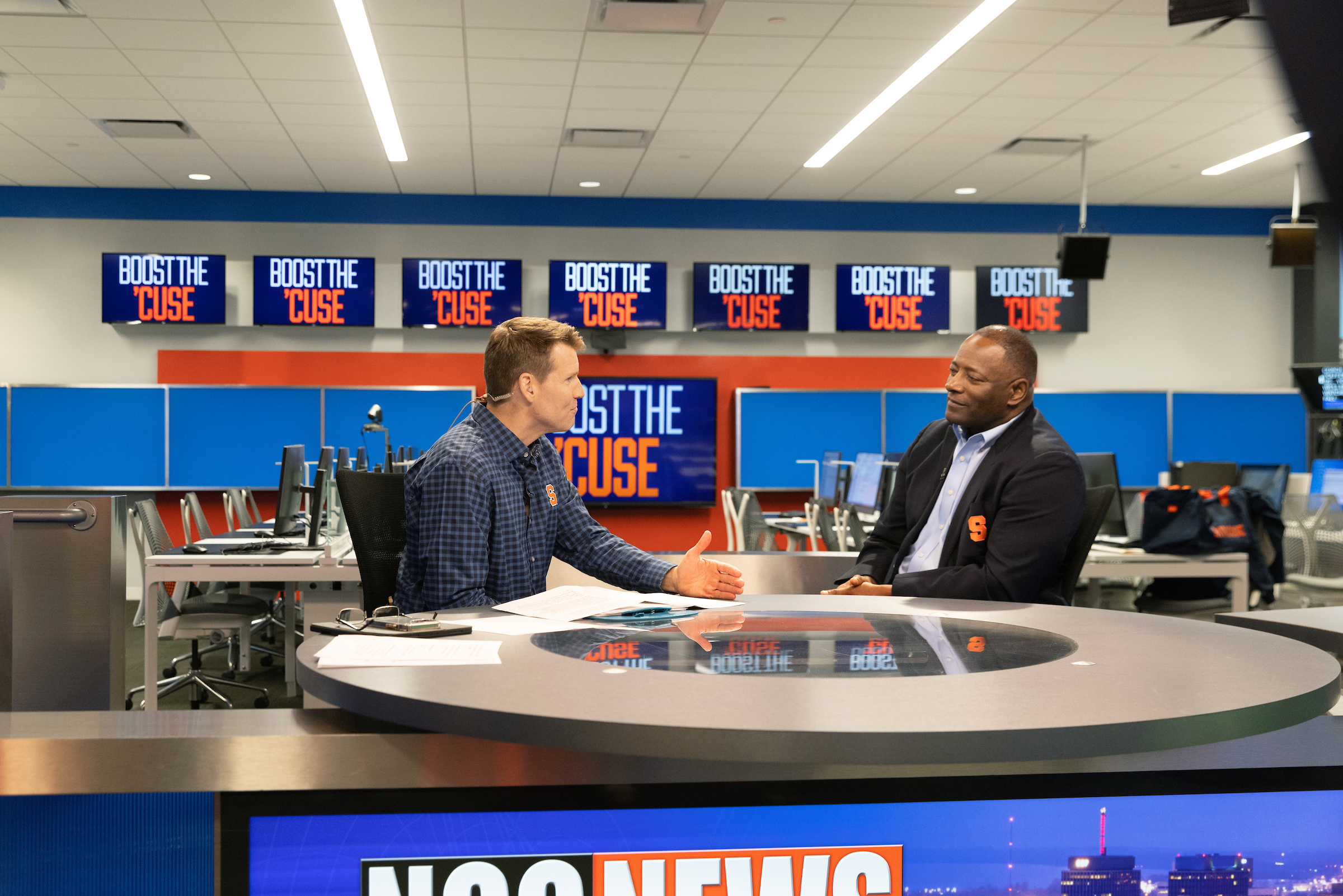 Two men sitting talking in a broadcast studio.