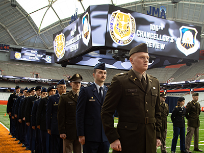 Group of people in military uniform standing in a line in the JMA Wireless Dome.