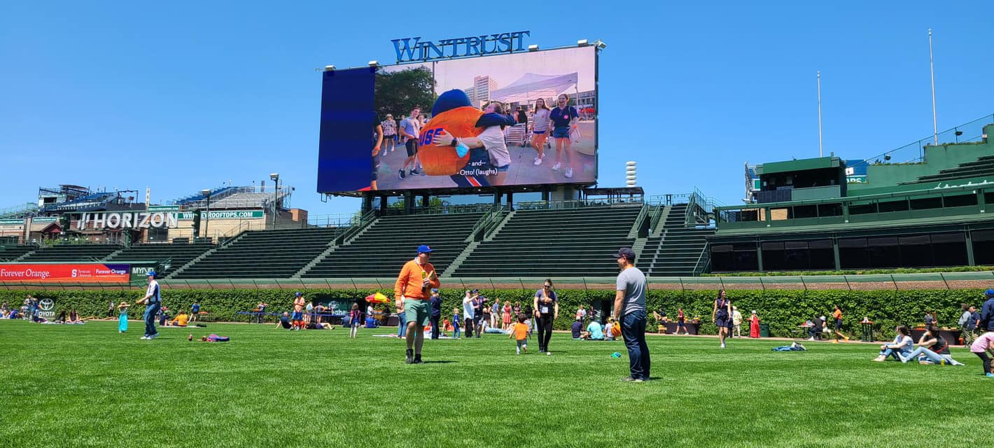 People walking around on the field of Wrigley Field.