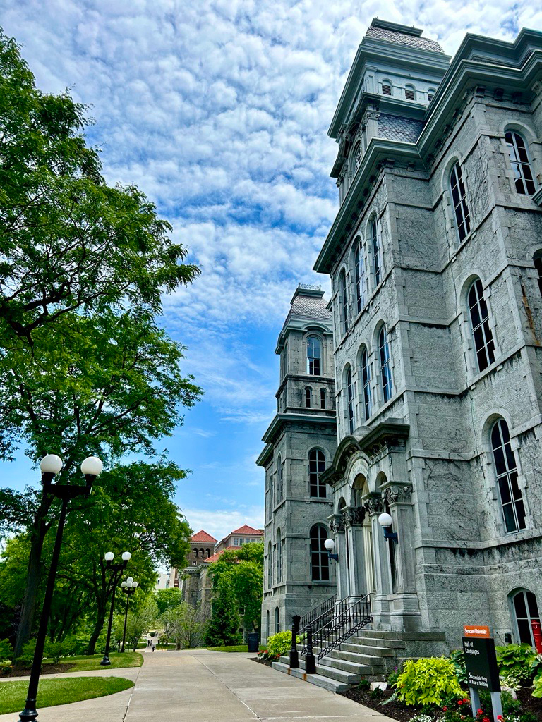 Exterior of Hall of Languages on a sunny day with blue sky and light clouds.