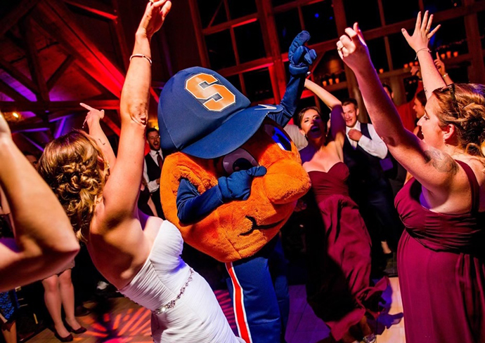 Otto dancing with a bride and other guests at a wedding.
