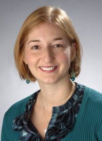 blonde woman with green shirt looking at camera