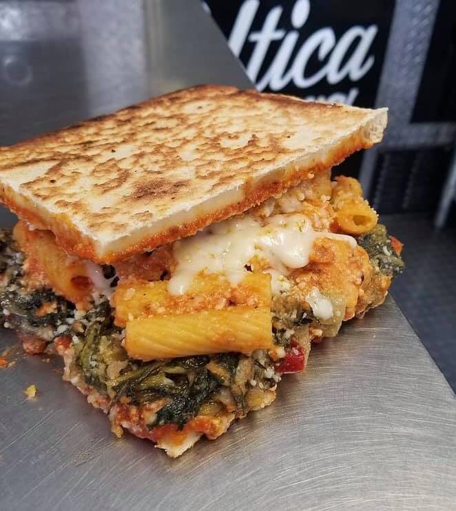 Sandwich with utica greens, chicken riggies in between pizza slices