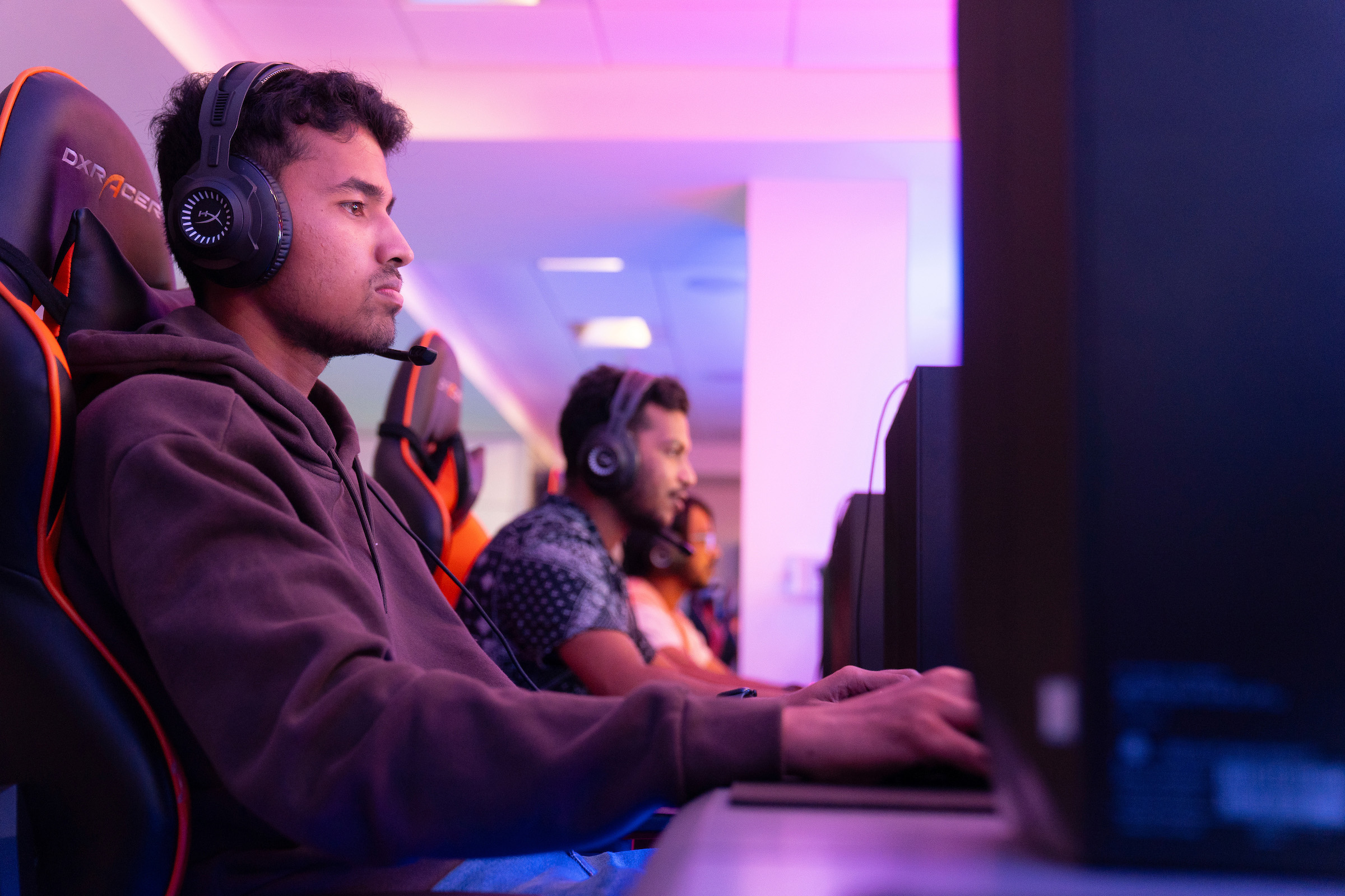 Individuals sitting at computers playing games.