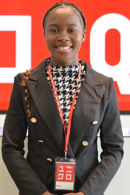 A woman smiles while posing for a headshot indoors.