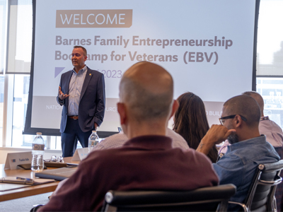 A man discusses entrepreneurship best practices to a group of veterans.