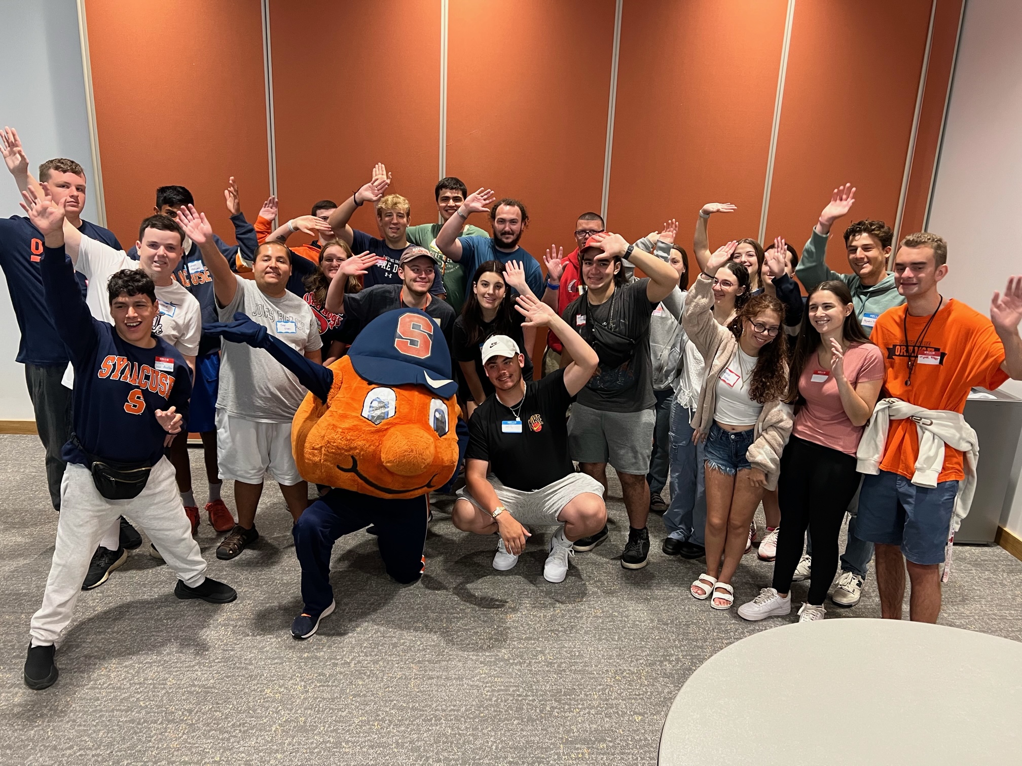 Large group of students posing together with Otto the Orange. 
