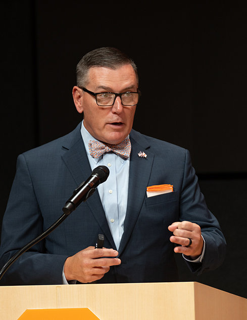 Man standing at a podium speaking.