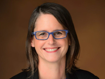 A woman smiles while posing for a headshot.