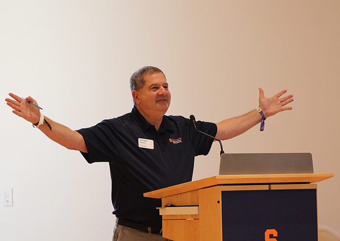 Individual standing at a podium with their arms extended