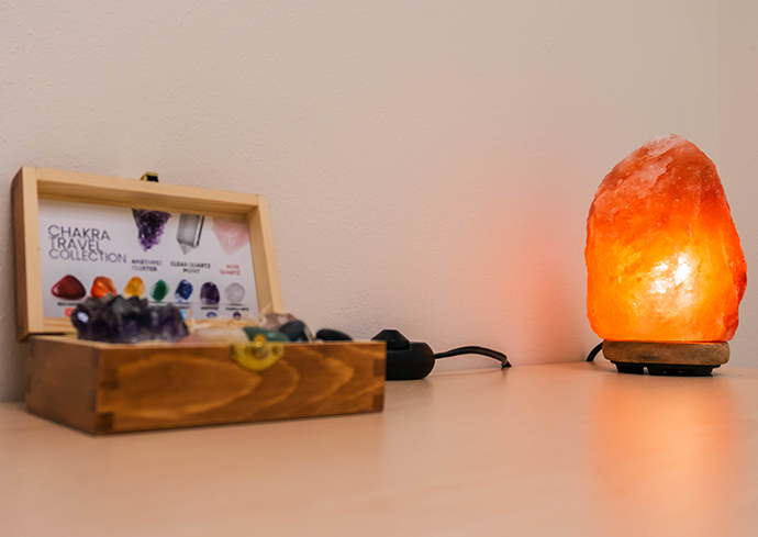 Table with crystals and a salt lamp on it