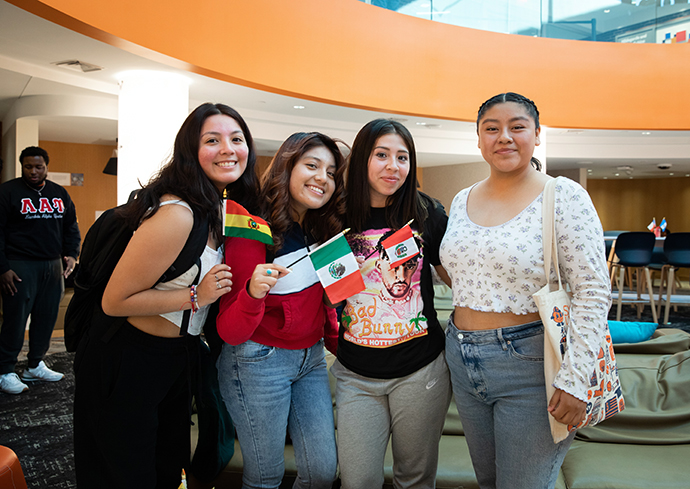Four students standing together in the Schine Student Center