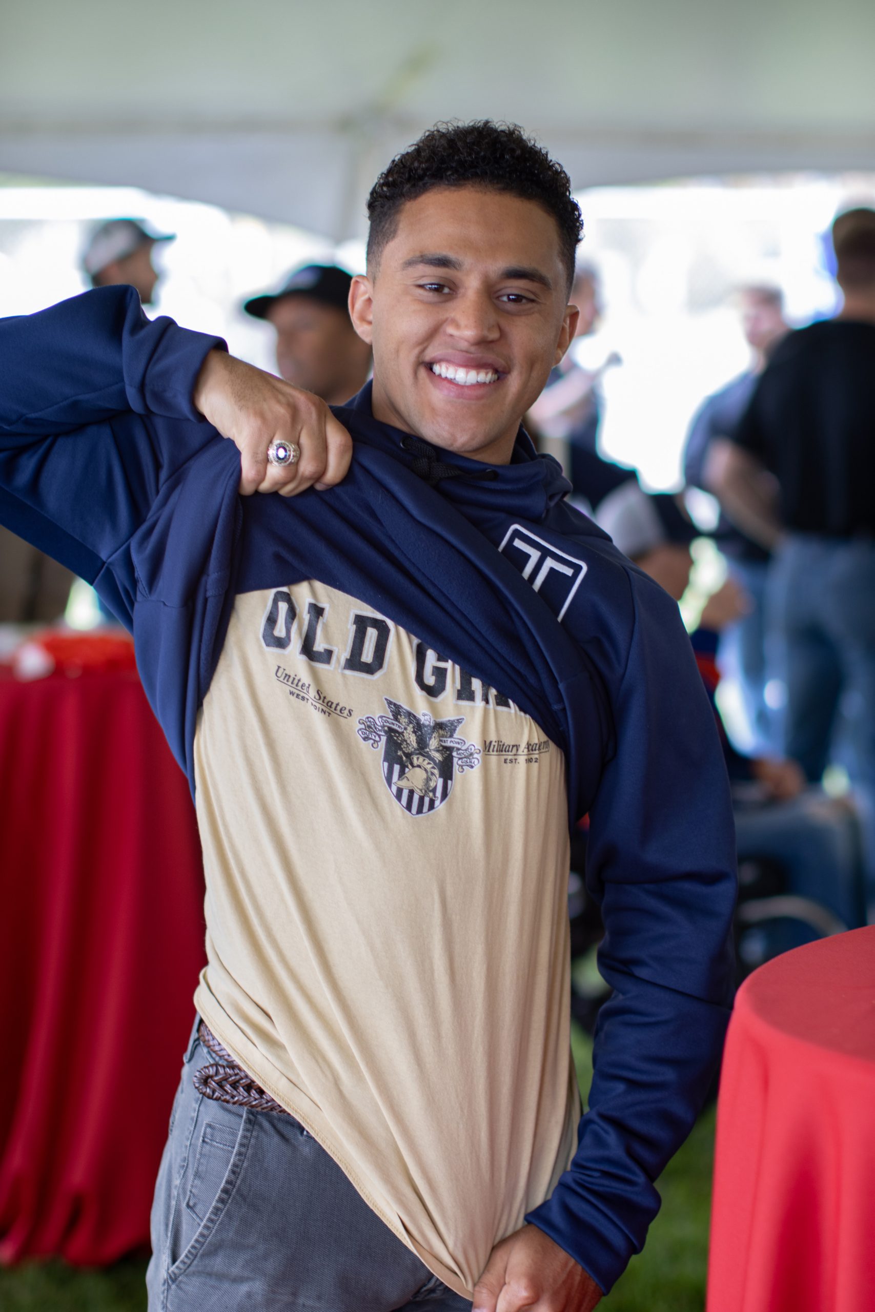 Individual pulling up their sweatshirt to show off their t-shirt.