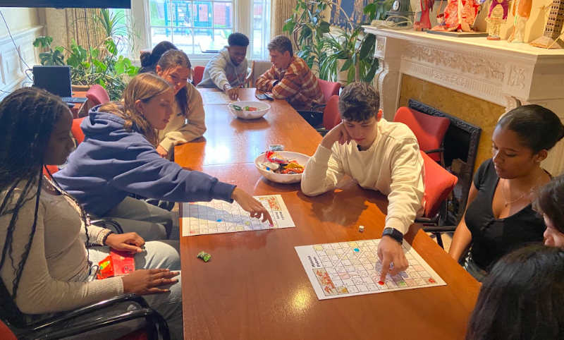 students looking at papers at a long conference table 