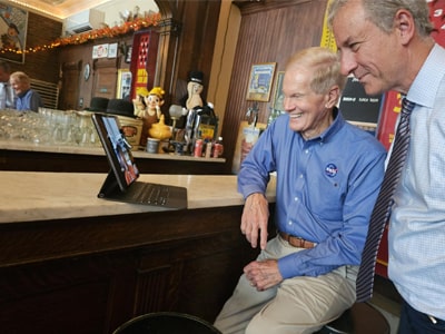 Two men participate in a FaceTime call with a Syracuse University student.