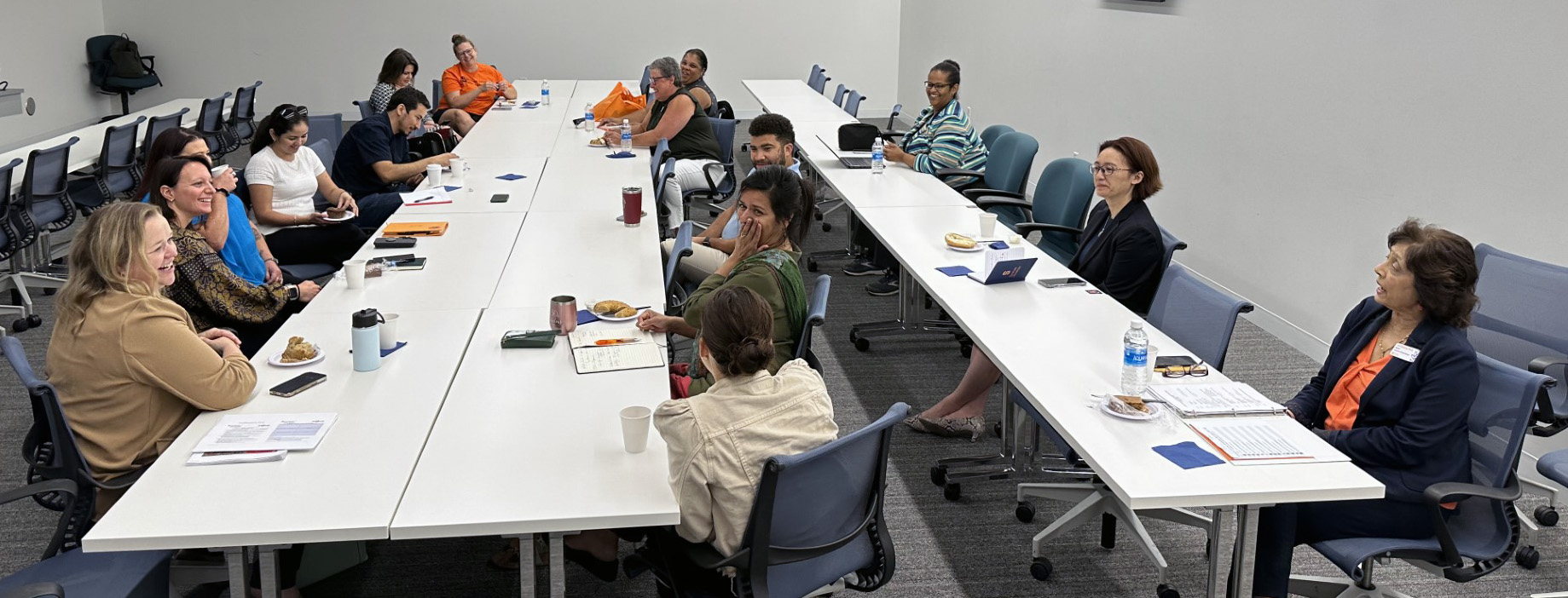 Staff members and instructors from InclusiveU and First Year Seminar collaborating at tables