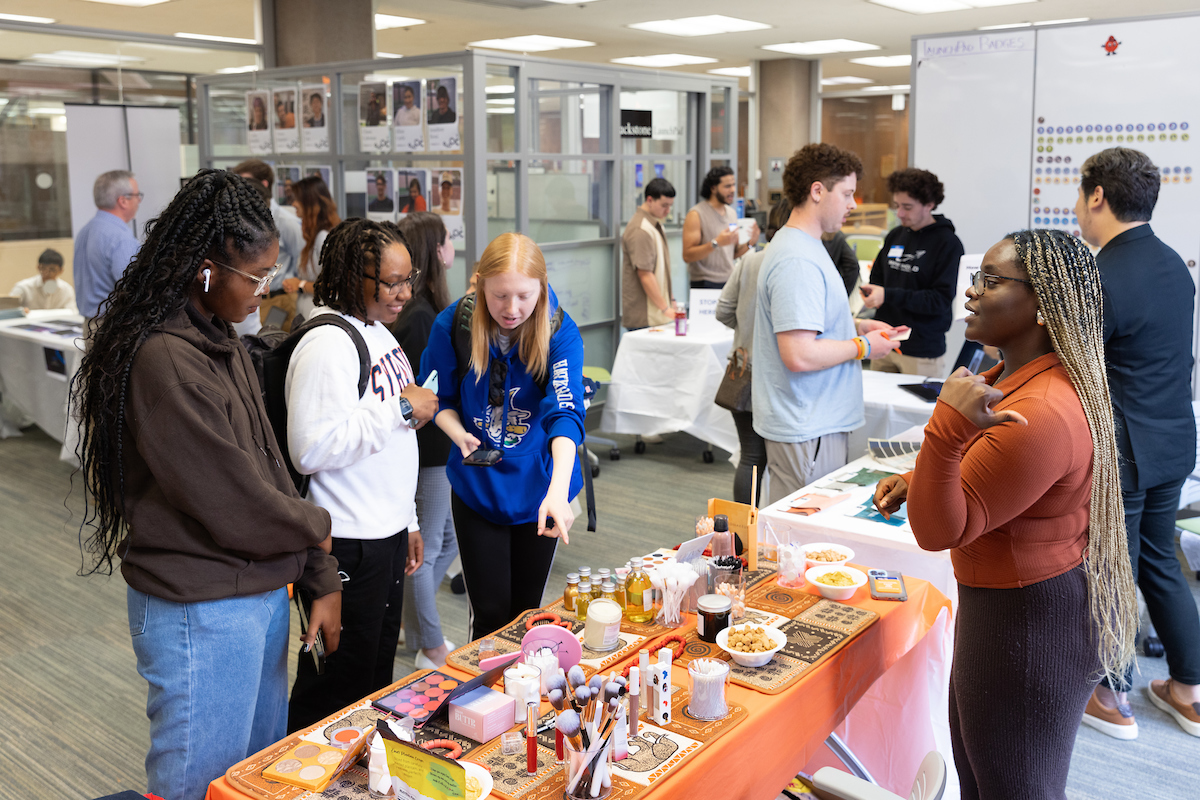 three people in front of a table filled with products
