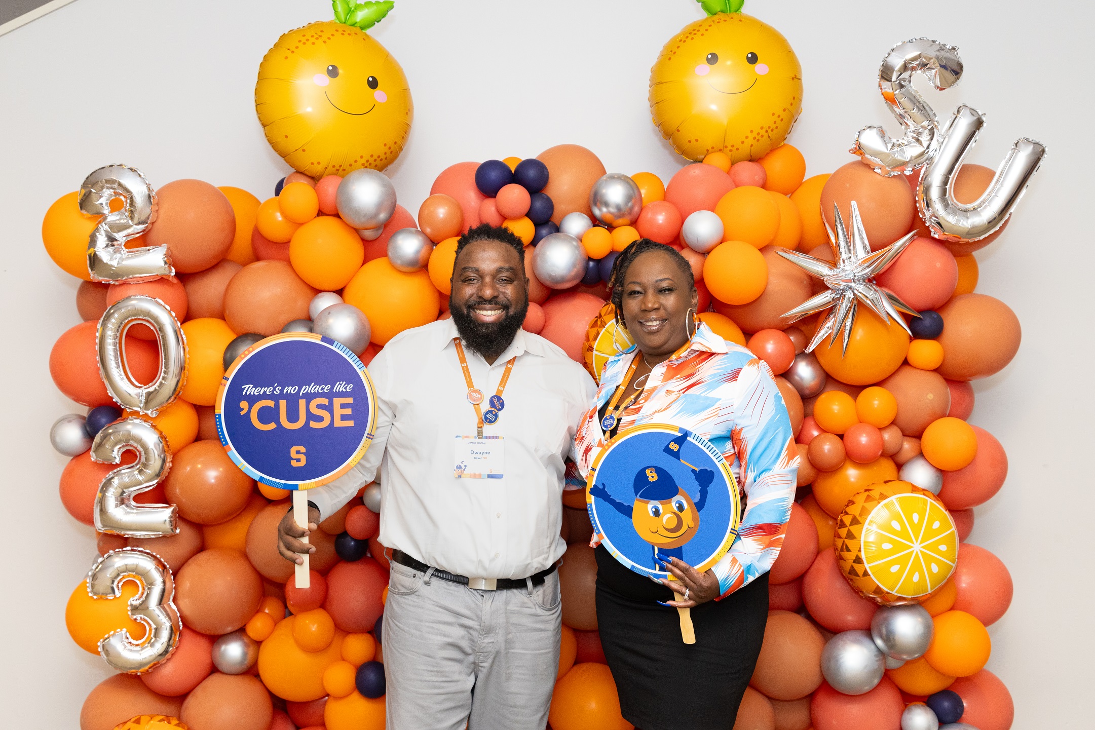 two people standing in front of a balloon display