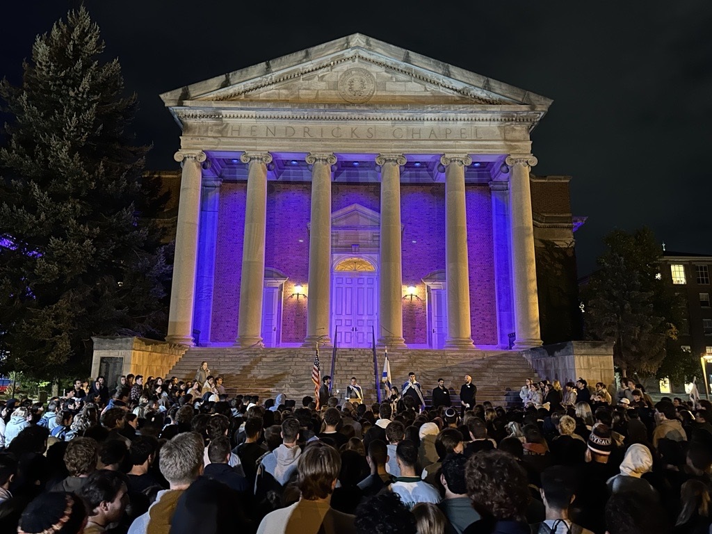 crowd of people in front of Hendricks Chapel at night