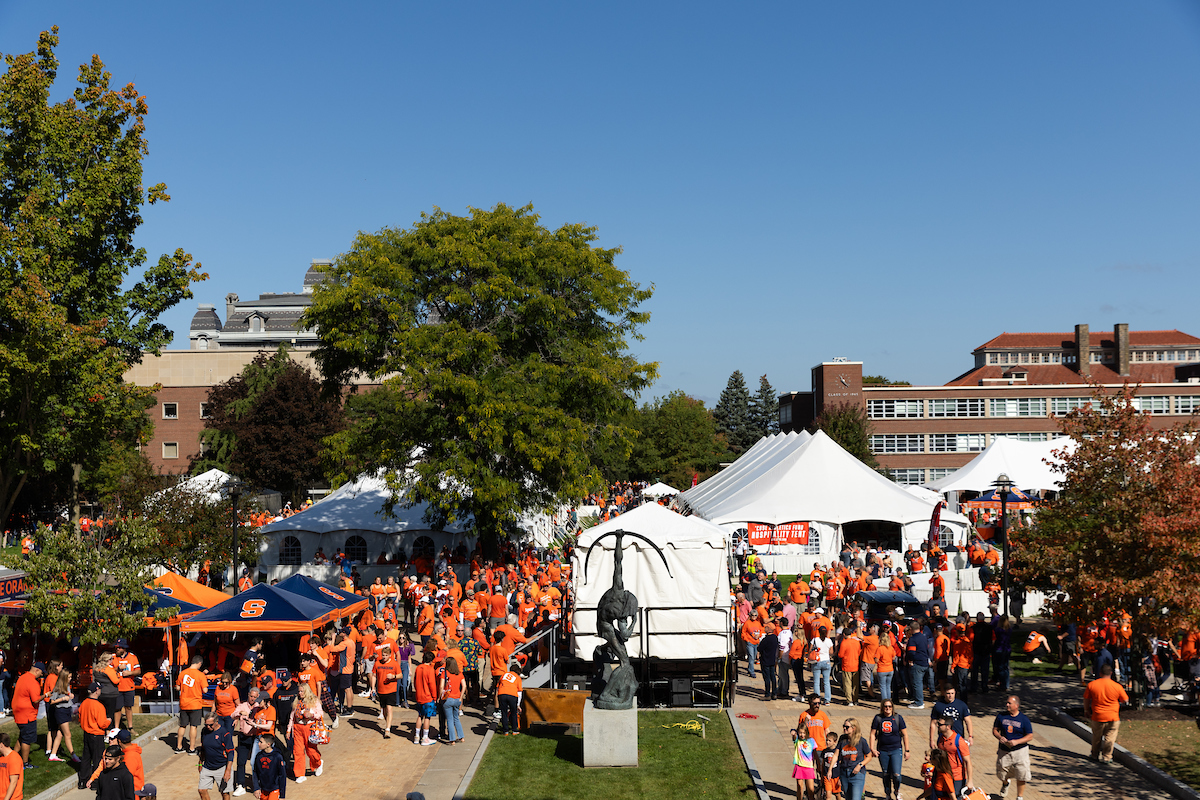 people wander among tents on the Quad