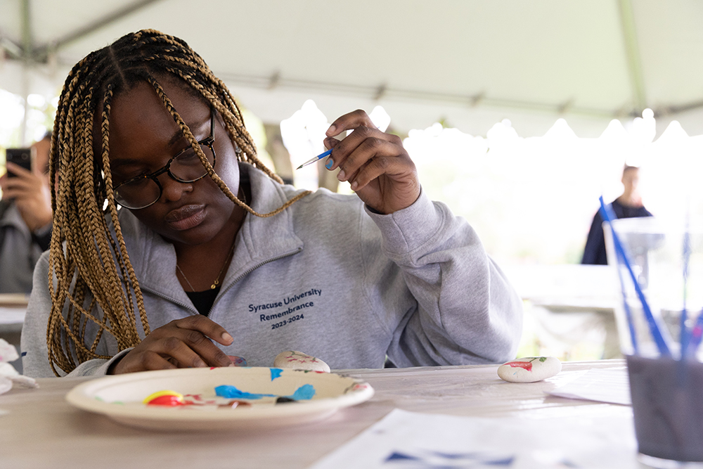 Student painting a stone during Remembrance Week