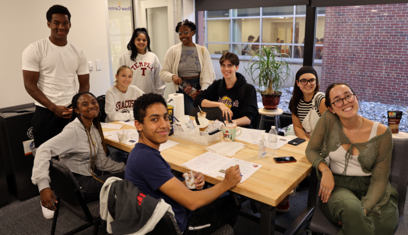 smiling students look forward as they work on a project together