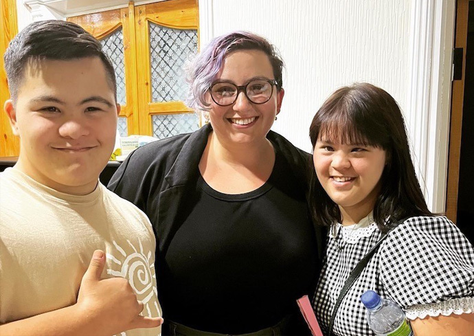 Graduate student standing with two students with disabilities
