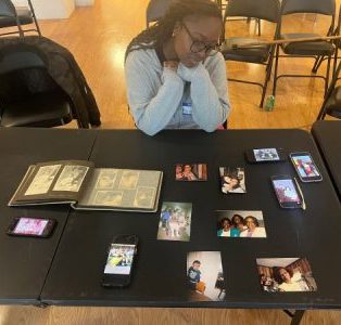 young woman looking at collection of family photographs