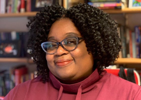 A woman poses for a headshot while indoors.