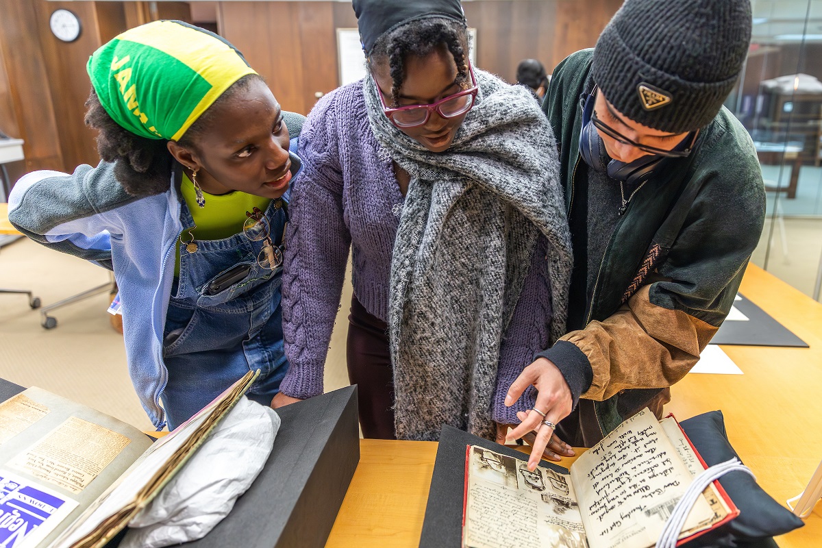 three people looking at scrapbooks