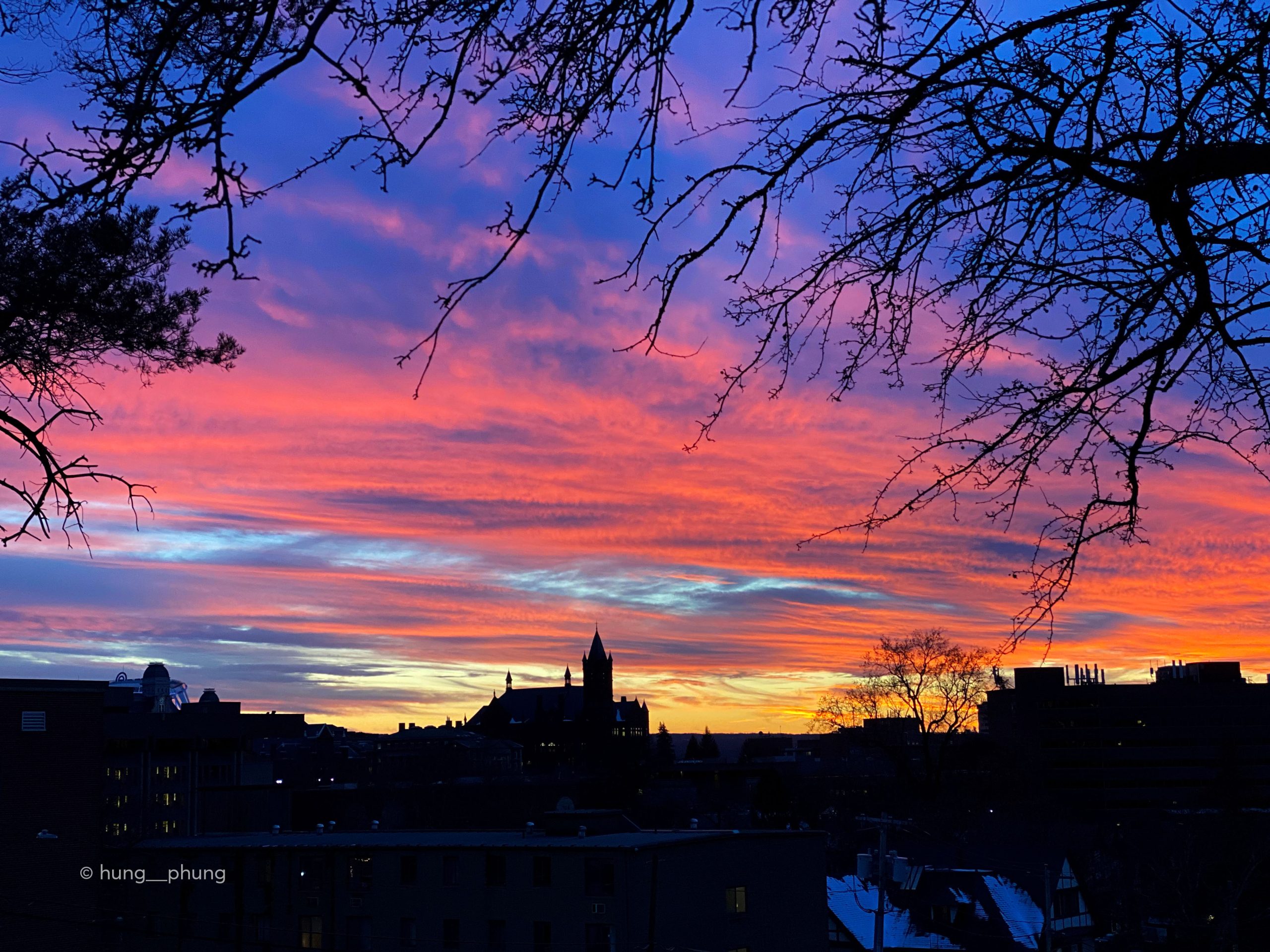 Beautiful sunset with shades of orange, pink, purple and blue over campus.