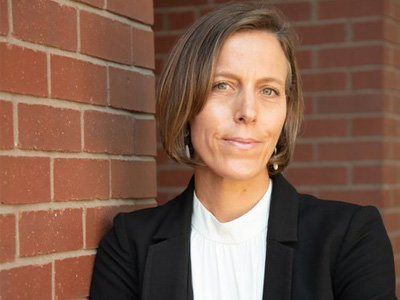 Portrait of art history professor Sascha Scott in front of a brick building