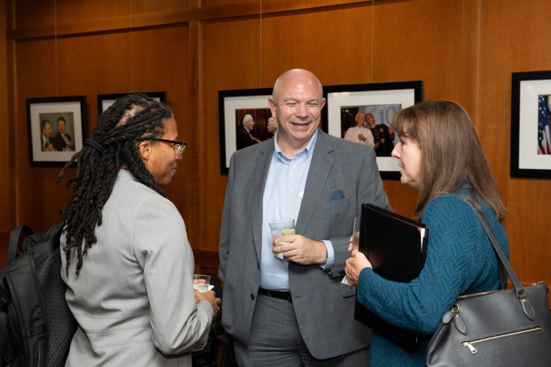 three people speaking at a reception