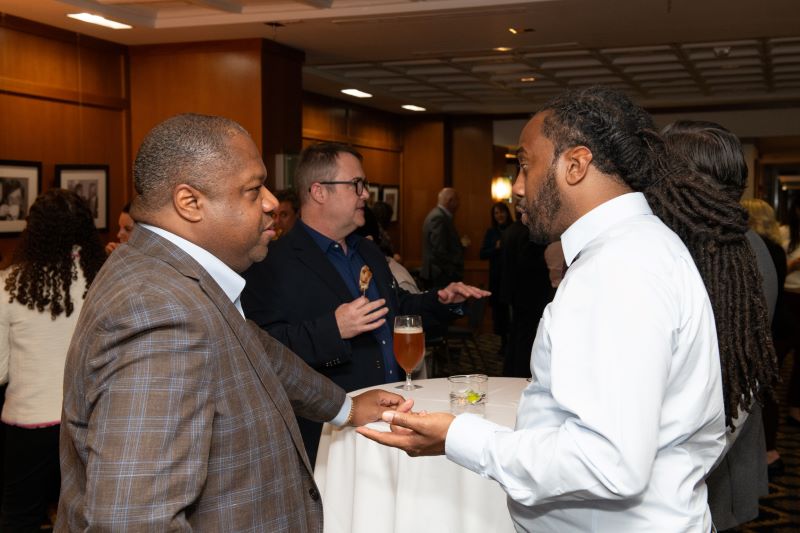 two persons speaking at a reception table