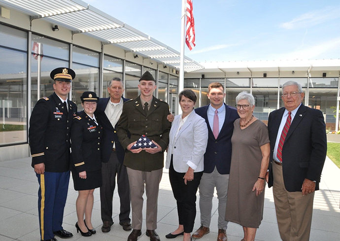 group of people standing in front of a flagpole
