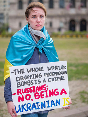 Yulia Bychkovsha holds a sign at a rally in Boston