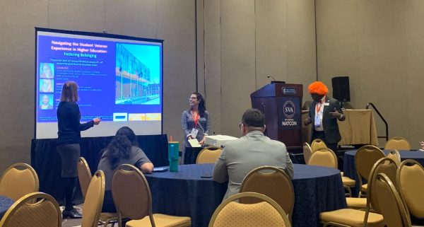 people doing a presentation in front of tables of people