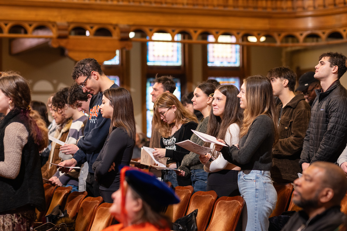 Group of students standing in their seats in the Setnor auditorium.