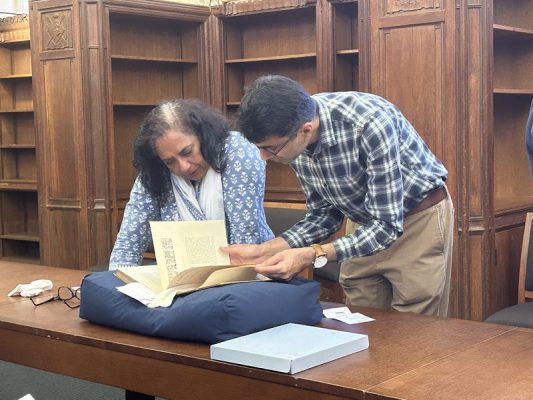 Symposium participants study a rare book