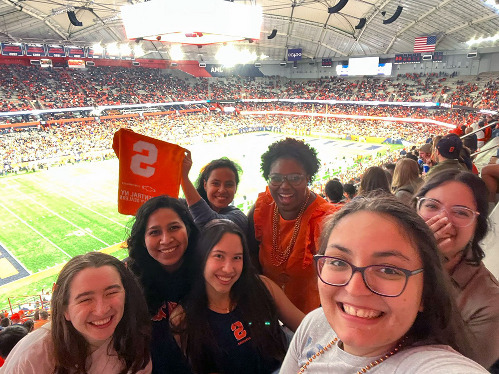 group of students take a selfie at a football game