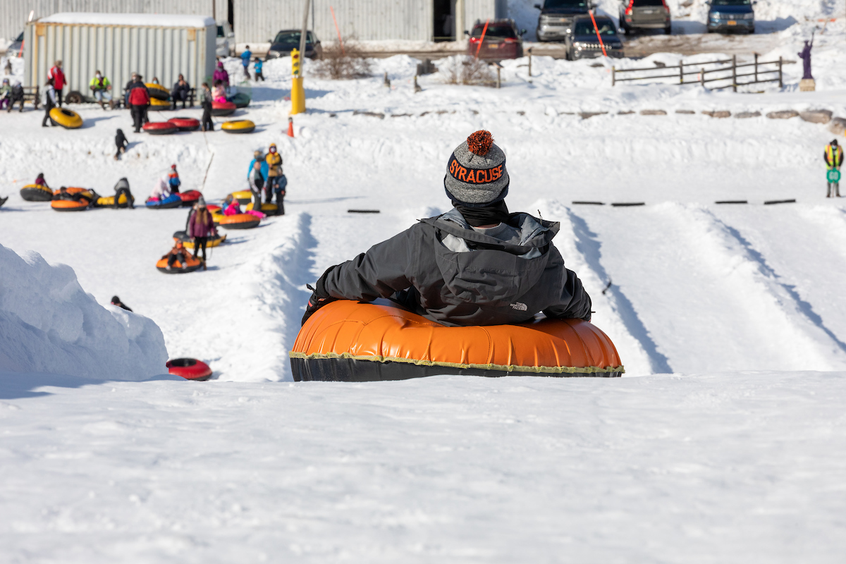 Person on a snow tube going down a hall 