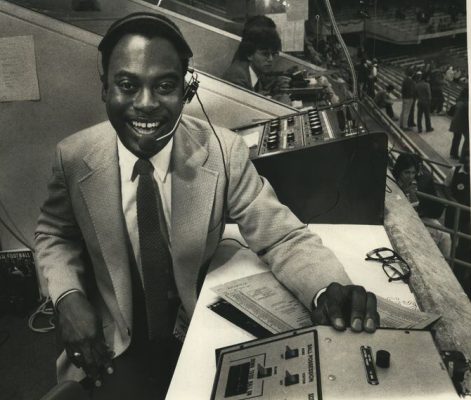 A man smiles while on the radio mic.