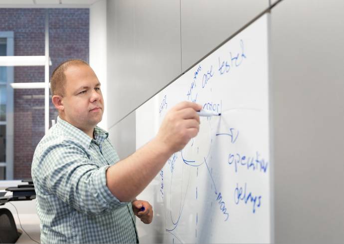 person writing on a white board
