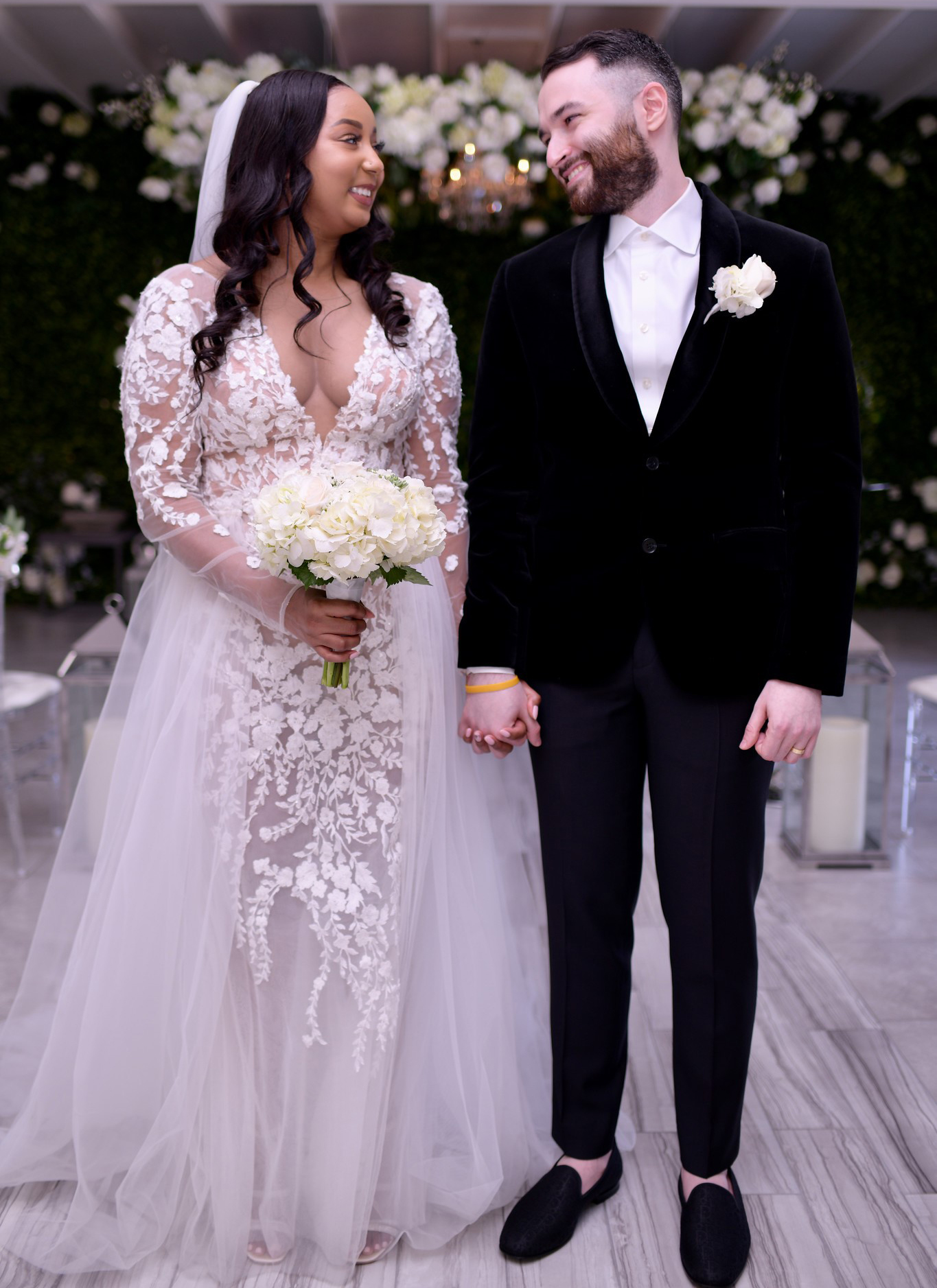 A bride and groom standing together holding hands. 